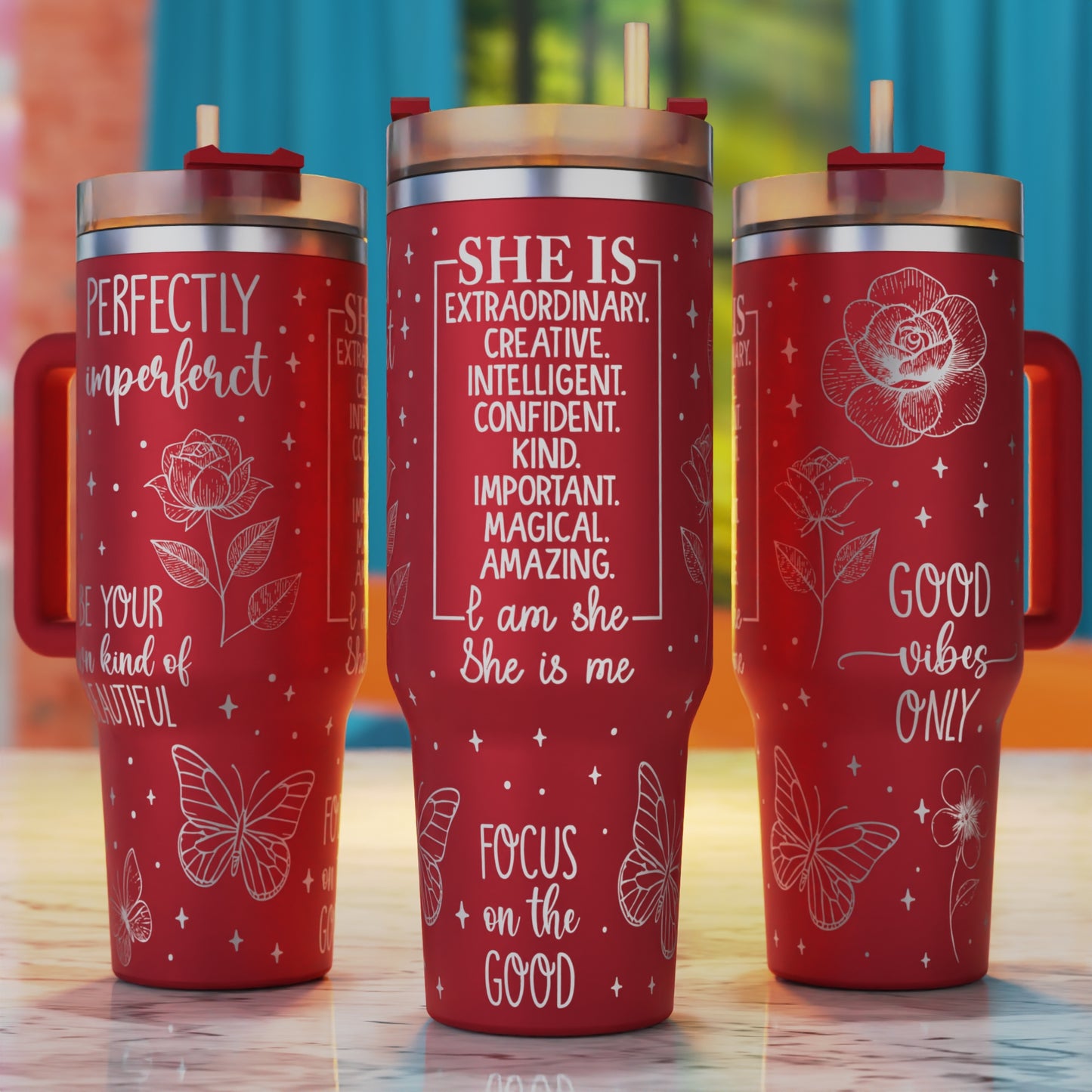 Three red tumblers with motivational quotes and designs 